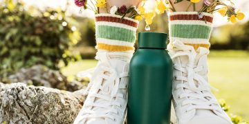 person wearing white and yellow floral rain boots