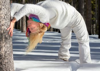 woman backlifting beside tree